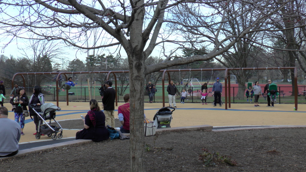 View of Swings via Central area in middle of playground 